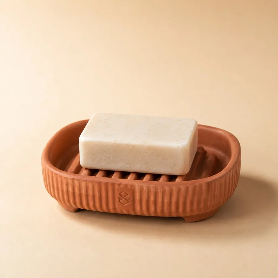 Fluted terracotta soap dish holding a cream soap bar